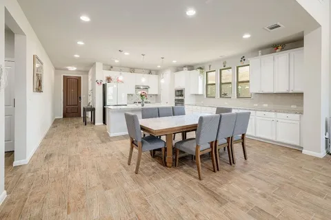 a view of a dining area with furniture wooden floor and a kitchen