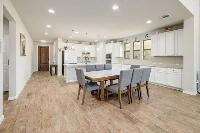 a view of a dining area with furniture wooden floor and a kitchen