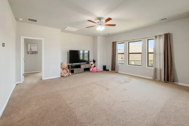 a view of a livingroom with a flat screen tv and windows