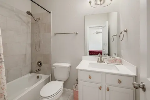 a bathroom with a toilet sink vanity tub and shower