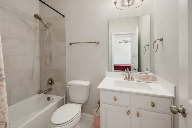 a bathroom with a toilet sink vanity tub and shower