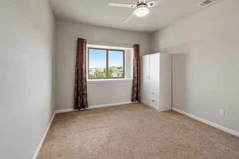 an empty room with windows and fan