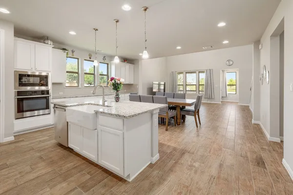 a large kitchen with kitchen island a sink stainless steel appliances and cabinets