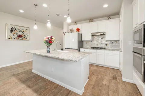a kitchen with kitchen island a sink stainless steel appliances and cabinets