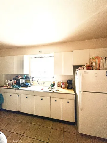 a kitchen with a sink a stove and white cabinets