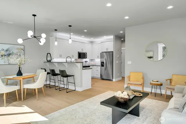 a living room with furniture kitchen view and a chandelier