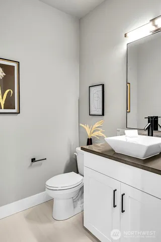 a bathroom with a granite countertop toilet sink and mirror