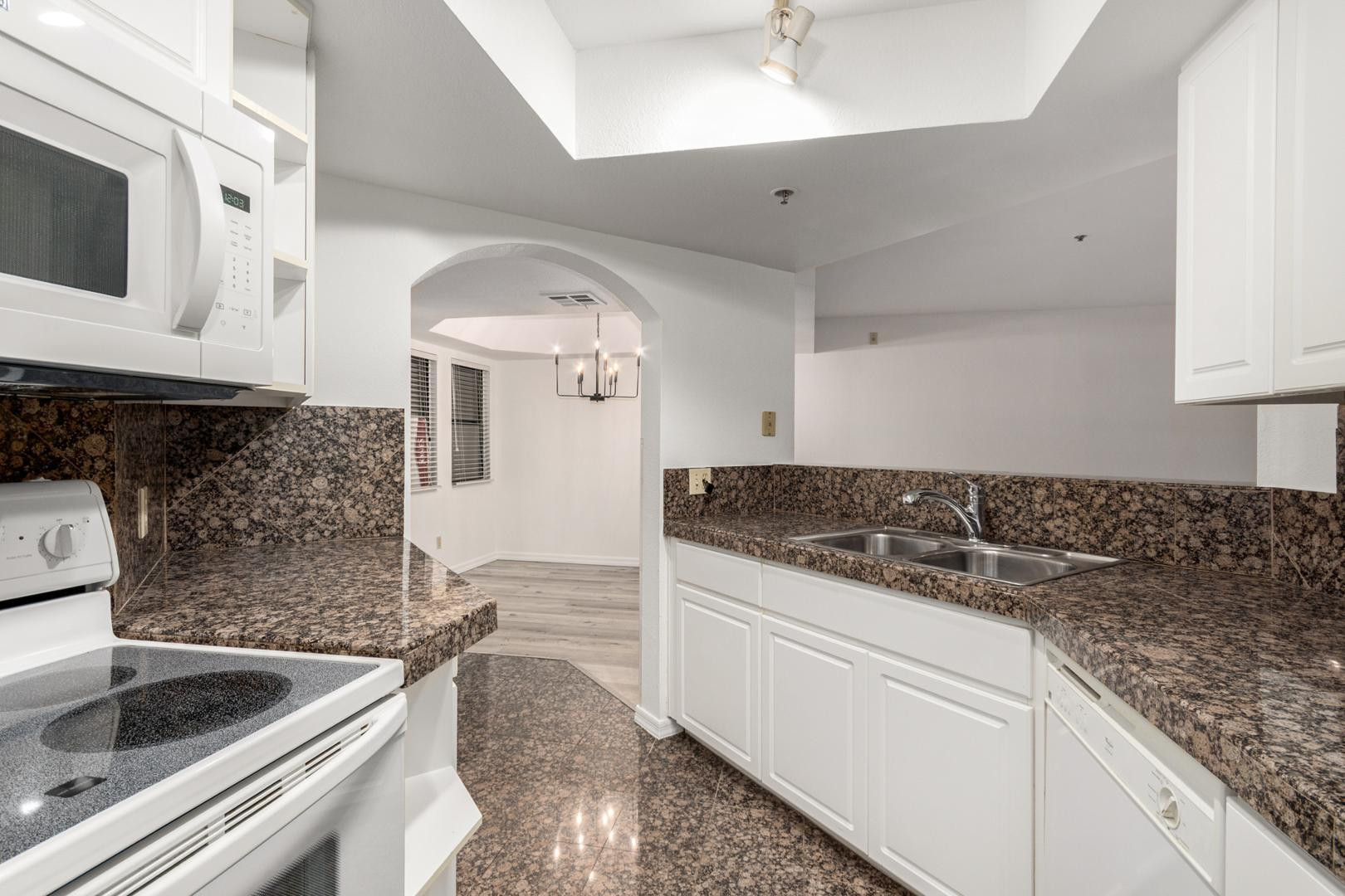 5104 North 32nd Street, Unit 225 Phoenix, AZ 85018 - Photo 21 of 31 a kitchen with granite countertop a sink and cabinets