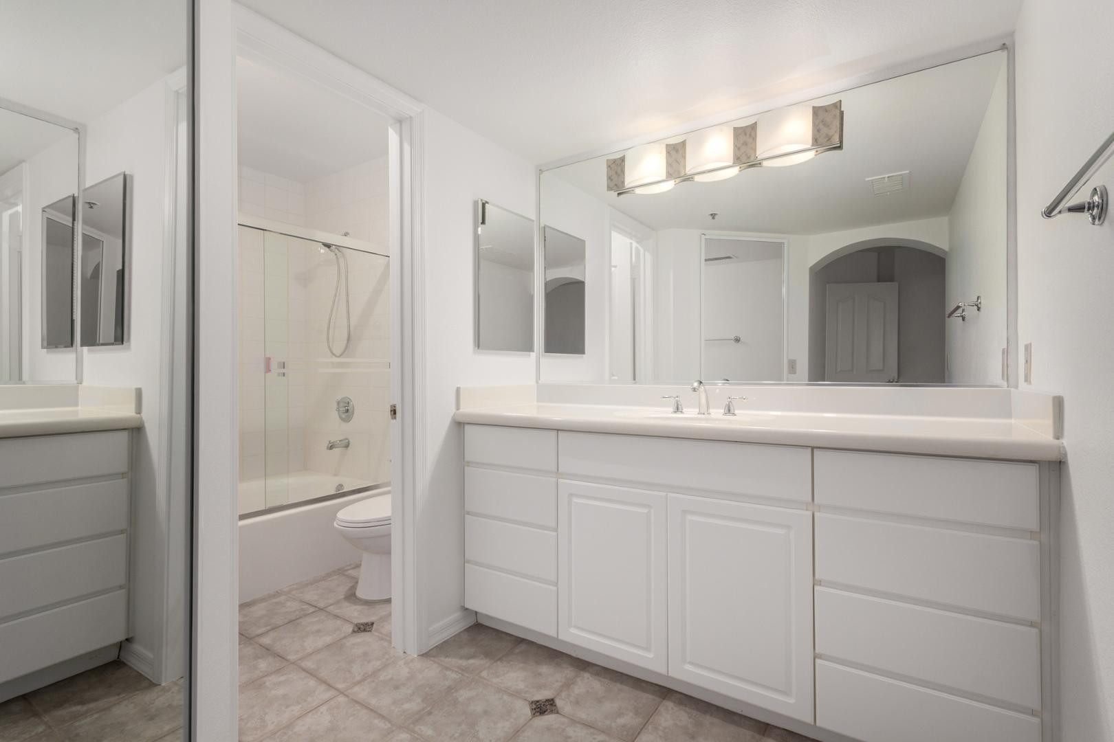 5104 North 32nd Street, Unit 225 Phoenix, AZ 85018 - Photo 9 of 31 a bathroom with a toilet a sink a mirror and a shower