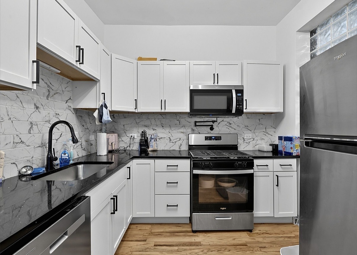 6602 South Marquette Road Chicago, IL 60637 - Photo 14 of 24 a kitchen with stainless steel appliances granite countertop a refrigerator stove a sink and white cabinets