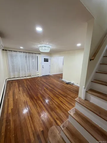 a view of a room with wooden floor and stairs