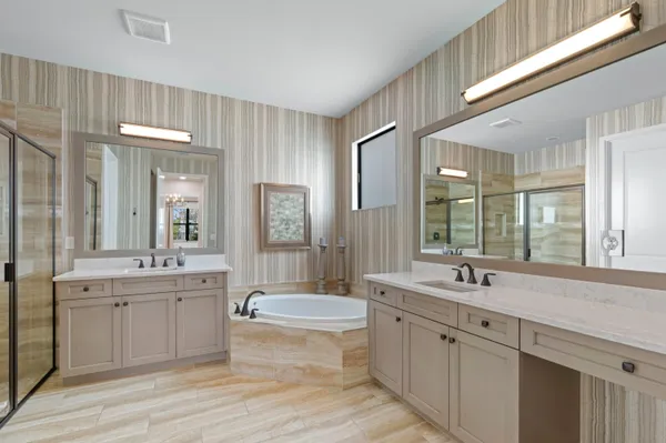 a spacious bathroom with a double vanity sink large mirror and a bathtub