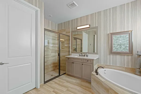 a bathroom with a tub a sink and a large mirror