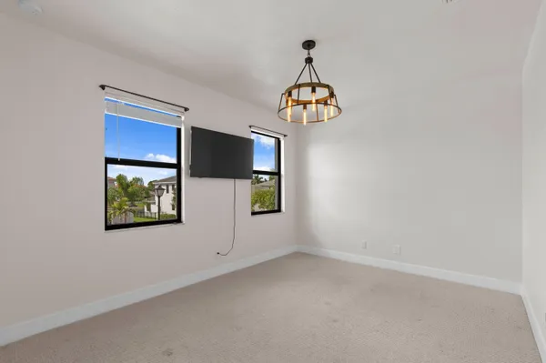 an empty room with windows and chandelier