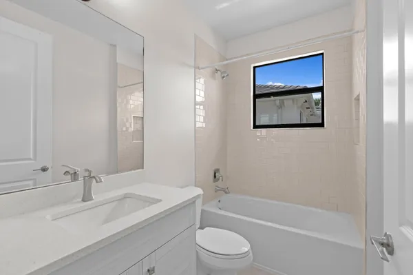 a bathroom with a toilet a sink a mirror and a bathtub