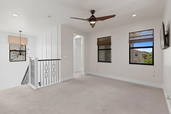 an empty room with windows and fan