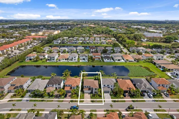 an aerial view of a city with lots of residential buildings ocean and mountain view in back
