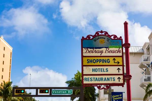 a view of a swimming pool with a yard and potted plants