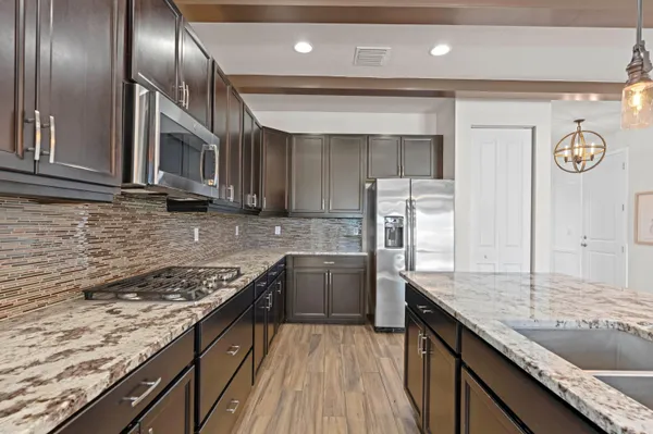 a kitchen with granite countertop stainless steel appliances window a refrigerator and wooden cabinets