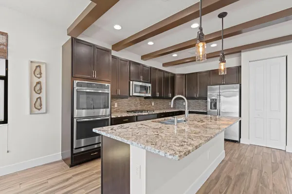 a kitchen with stainless steel appliances granite countertop a sink refrigerator and cabinets