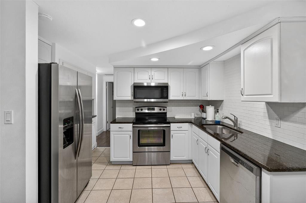 3214 Huntington Road Holiday, FL 34691 - Photo 11 of 26 a kitchen with granite countertop a refrigerator and a sink