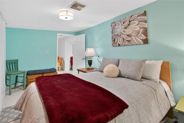 a bed room with a bed and a painting on the wall