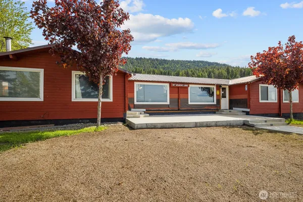 a view of a house with backyard and trees