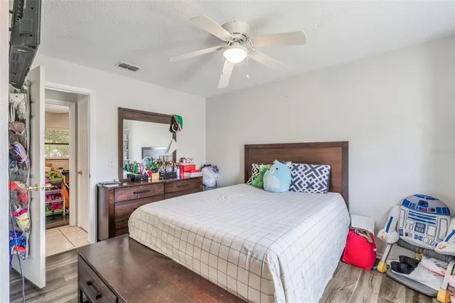 a bedroom with a bed and a large mirror on the dresser