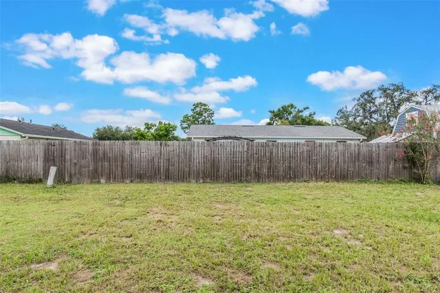 a view of garden with wooden fence