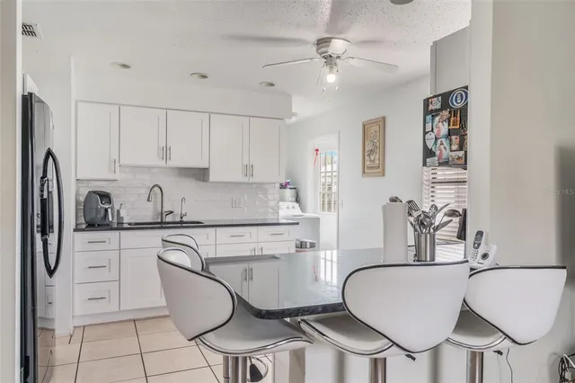 a kitchen with stainless steel appliances a dining table chairs and a refrigerator