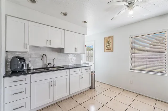 a kitchen with granite countertop white cabinets and white appliances