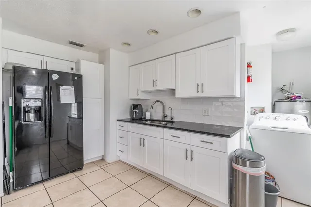 a kitchen with granite countertop a sink and refrigerator