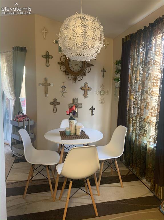 3748 Riviera Grove, Unit 203 Colorado Springs, CO 80922 - Photo 21 of 23 a view of a dining room with furniture and chandelier