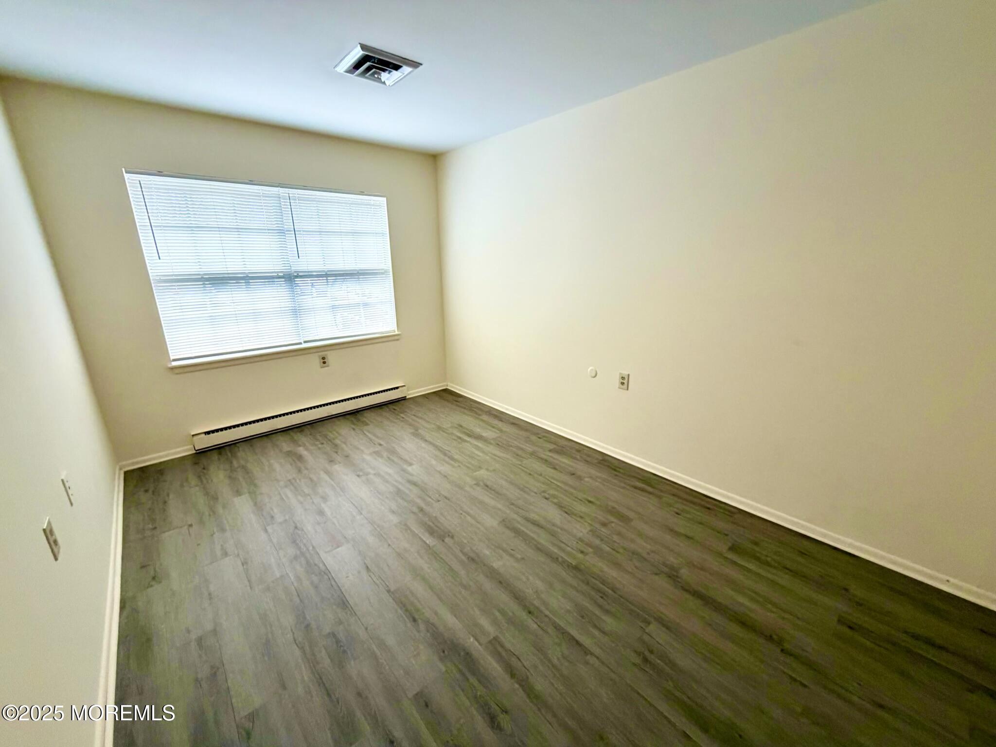 842 B Inverness Court Lakewood, NJ 08701 - Photo 14 of 18 an empty room with wooden floor and windows