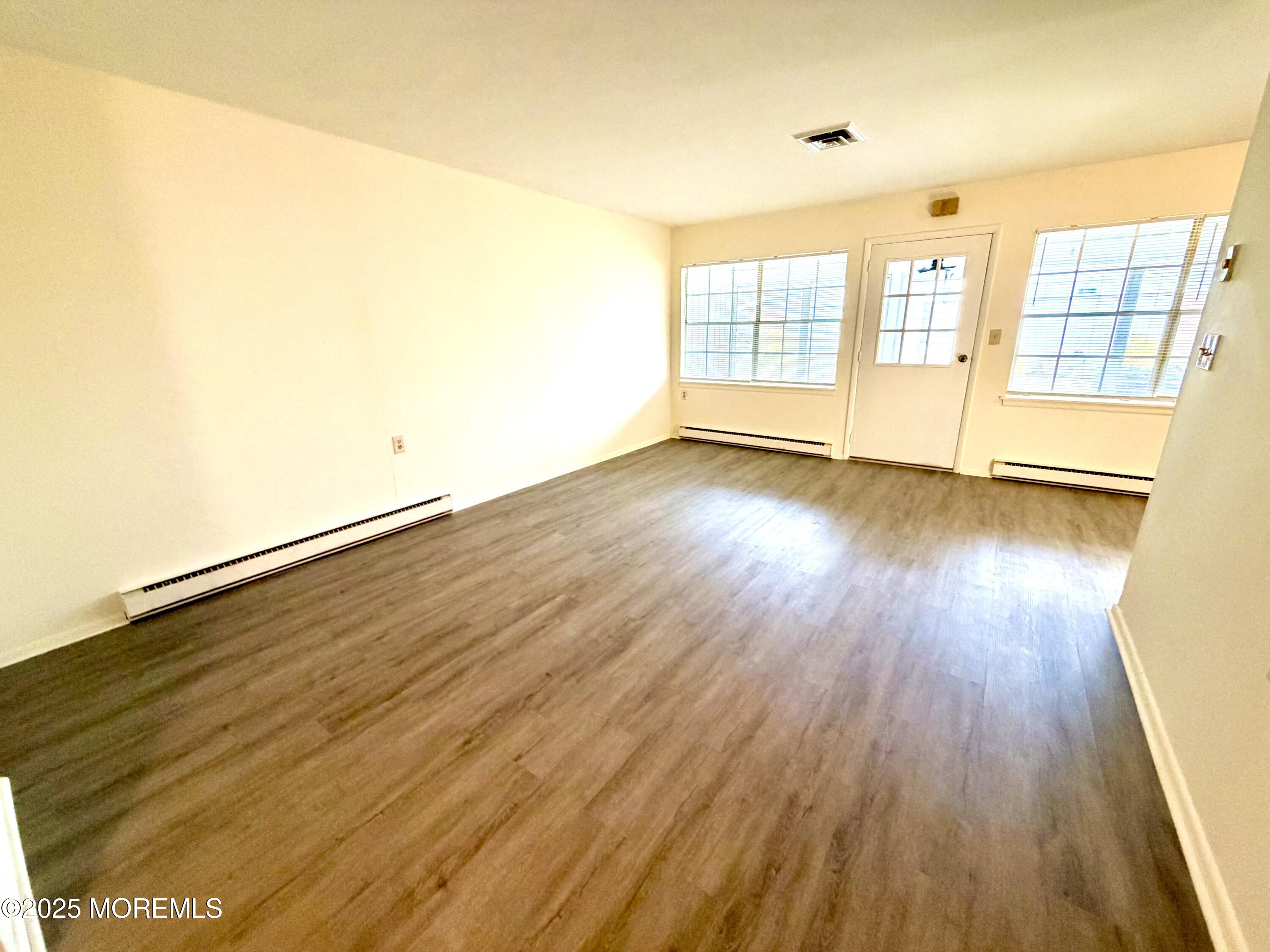 842 B Inverness Court Lakewood, NJ 08701 - Photo 3 of 18 wooden floor in an empty room with a window
