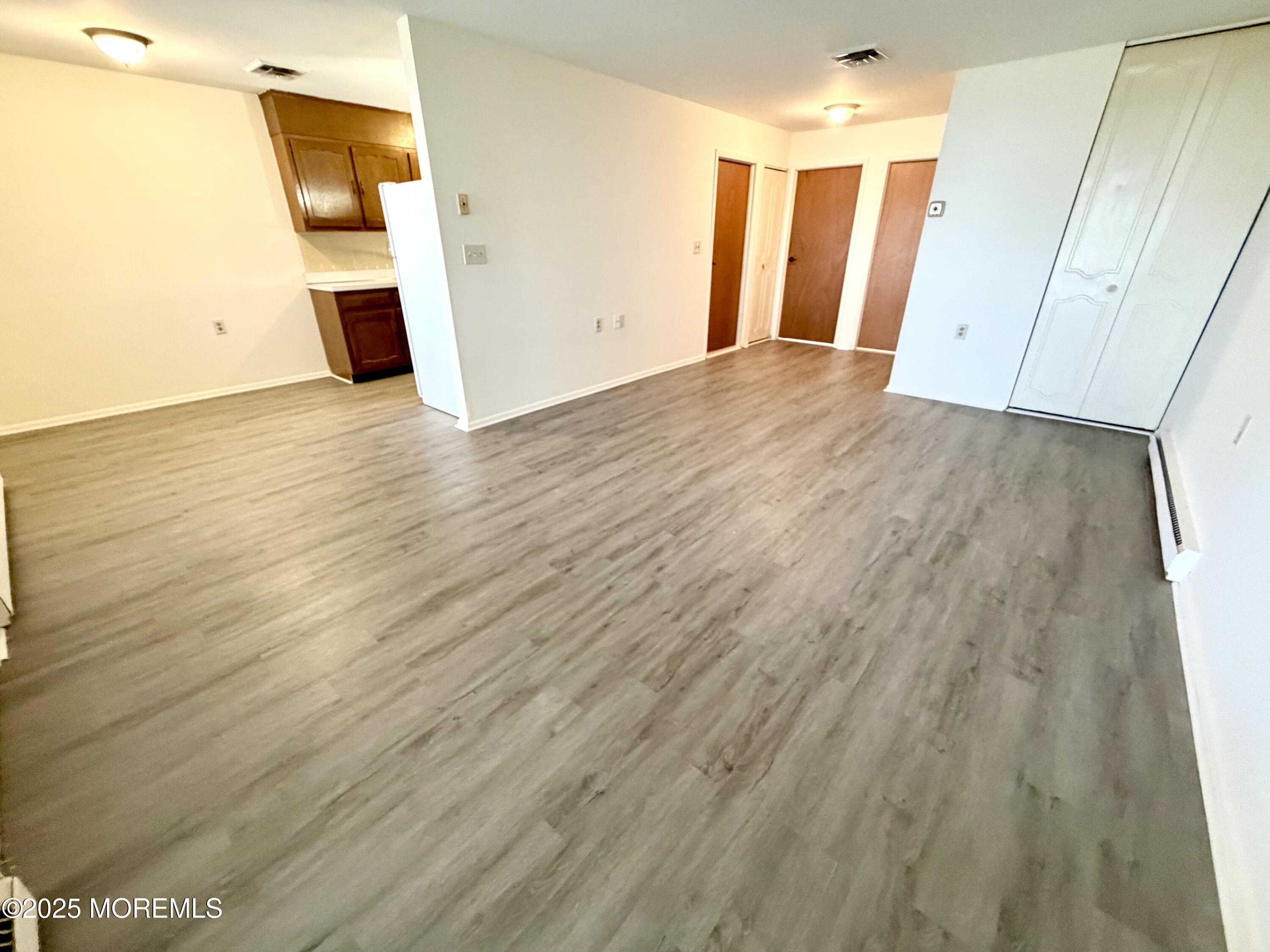 842 B Inverness Court Lakewood, NJ 08701 - Photo 5 of 18 a view of an empty room with wooden floor