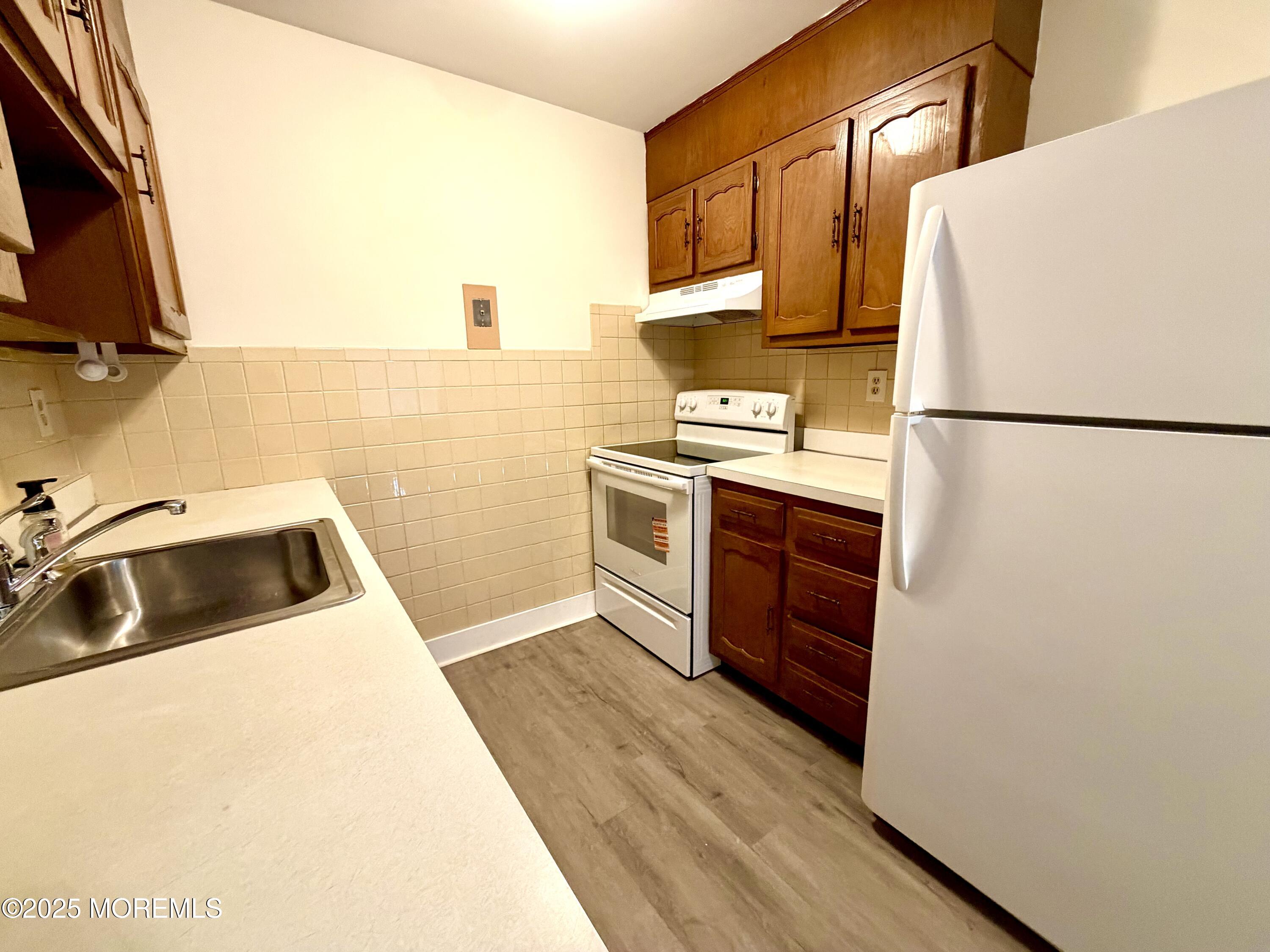 842 B Inverness Court Lakewood, NJ 08701 - Photo 7 of 18 a kitchen with a refrigerator sink and stove top oven