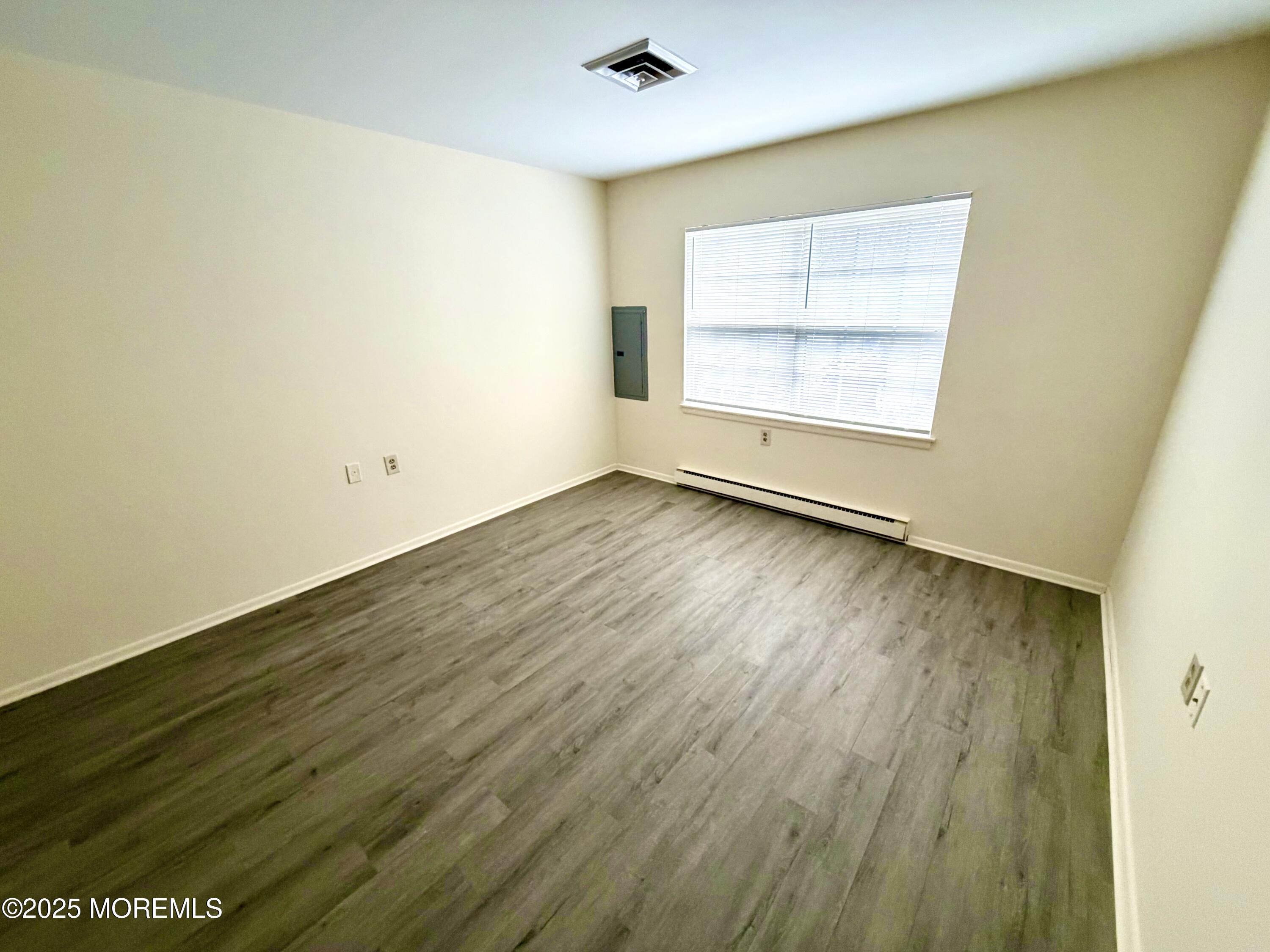 842 B Inverness Court Lakewood, NJ 08701 - Photo 10 of 18 an empty room with wooden floor and windows