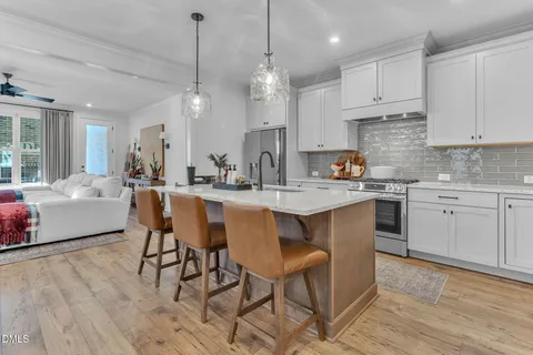 a kitchen with kitchen island granite countertop a sink a center island stainless steel appliances and cabinets