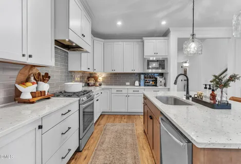 a kitchen with granite countertop a sink stove and cabinets