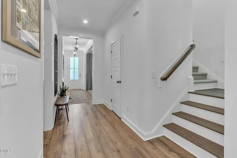 a view of a hallway with wooden floor and staircase