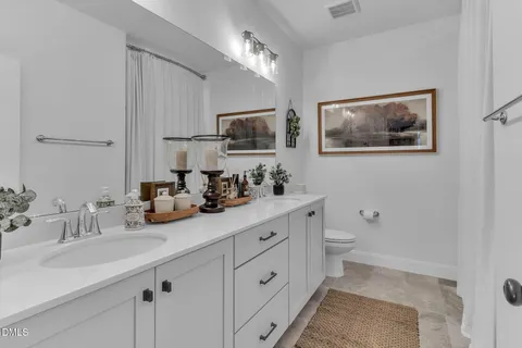 a bathroom with double sink and a mirror