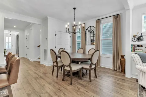 a view of a a dining room with furniture window and wooden floor