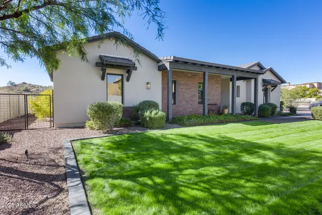 a front view of a house with a yard and potted plants