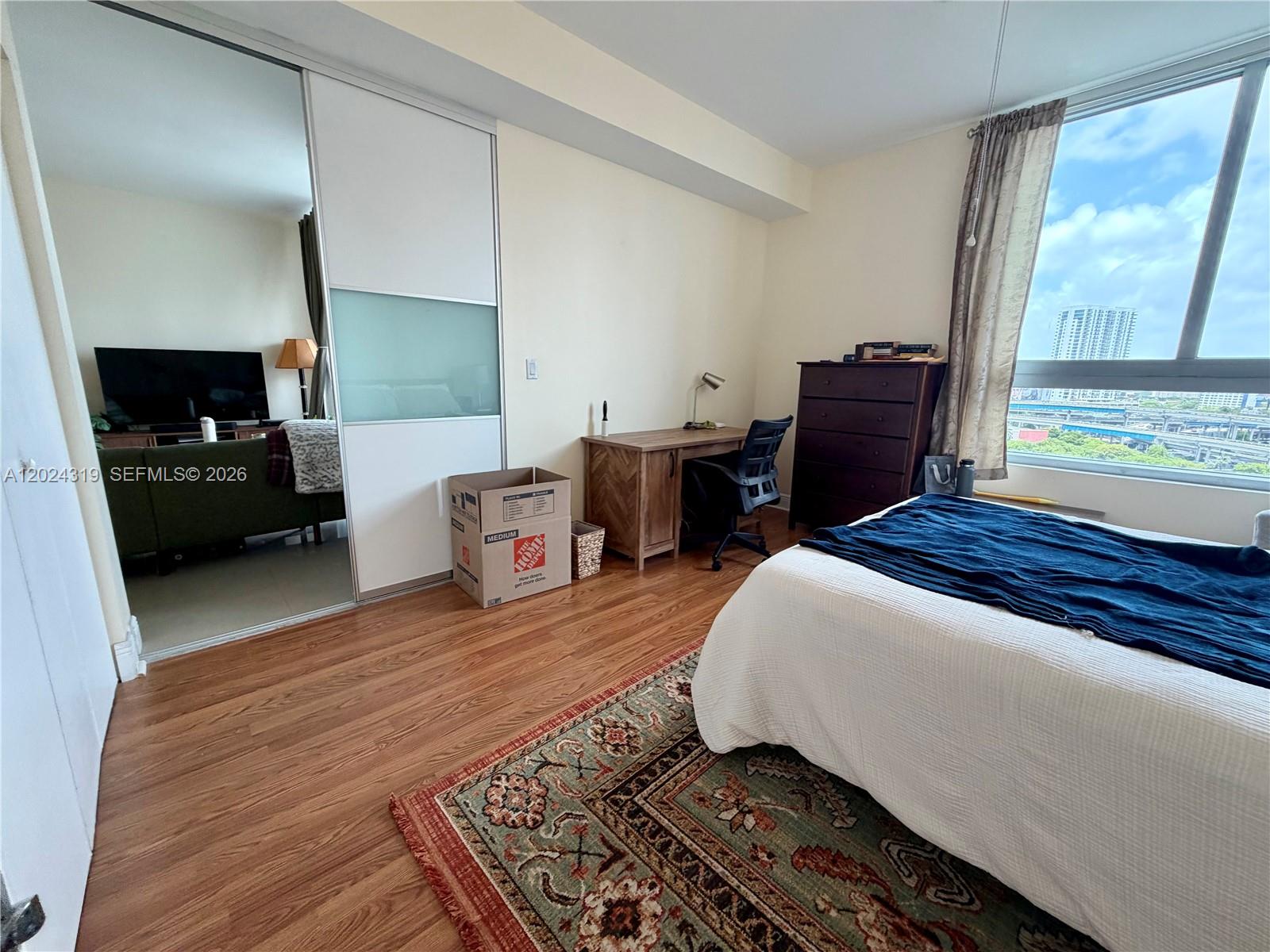 90 Southwest 3rd Street, Unit 1409 Miami, FL 33130 - Photo 12 of 25 a bedroom with a bed and wooden floor