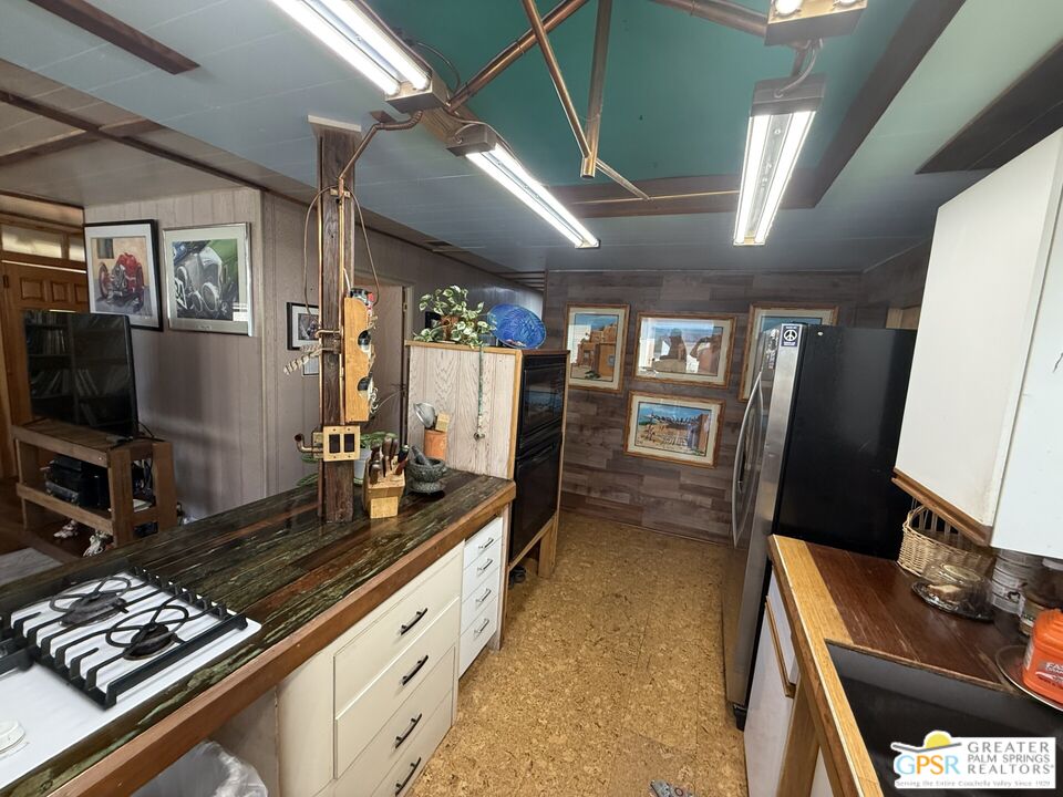 18131 Langlois Road, Unit H1 Desert Hot Springs, CA 92241 - Photo 11 of 44 a kitchen with stainless steel appliances granite countertop a stove and a refrigerator