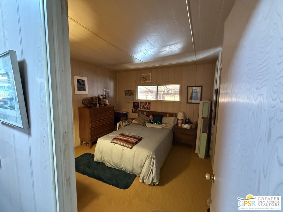 18131 Langlois Road, Unit H1 Desert Hot Springs, CA 92241 - Photo 16 of 44 a bed room with a bed furniture and a window