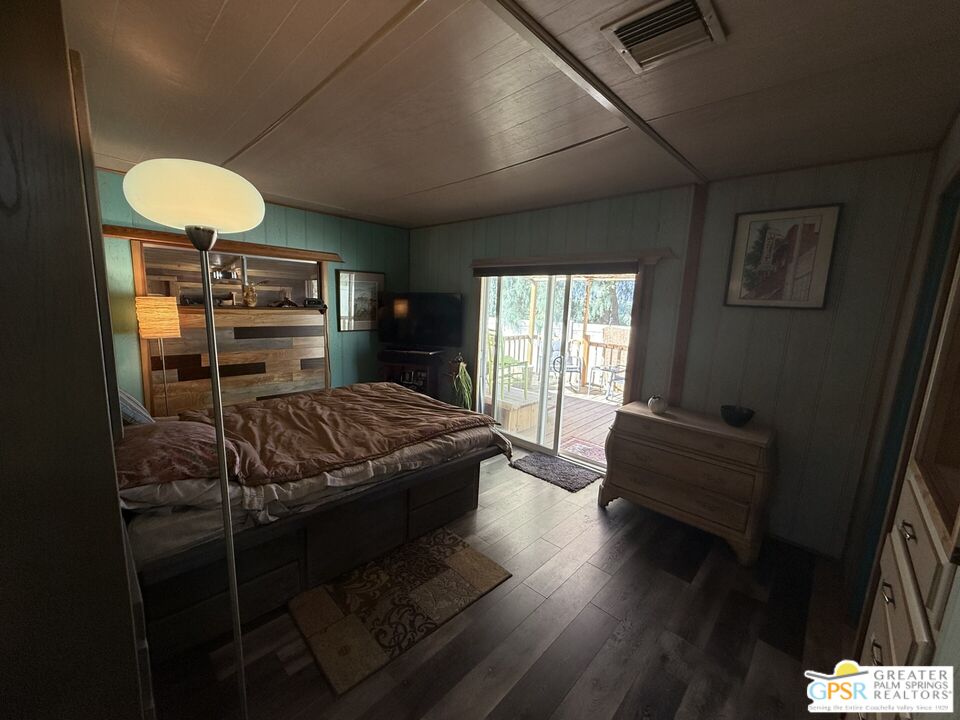 18131 Langlois Road, Unit H1 Desert Hot Springs, CA 92241 - Photo 18 of 44 a bedroom with a bed and wooden floor