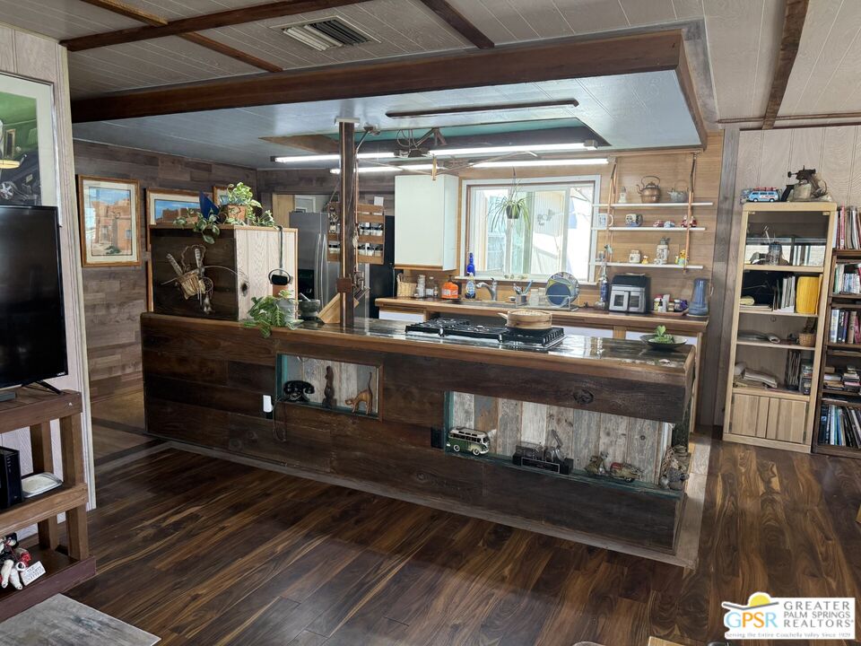 18131 Langlois Road, Unit H1 Desert Hot Springs, CA 92241 - Photo 10 of 44 a room with stainless steel appliances kitchen island granite countertop a stove and a wooden floor
