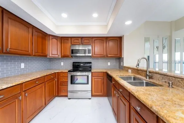 a kitchen with stainless steel appliances granite countertop a sink stove and cabinets